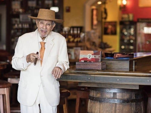 avo uvezian standing at bar table cigar boxes
